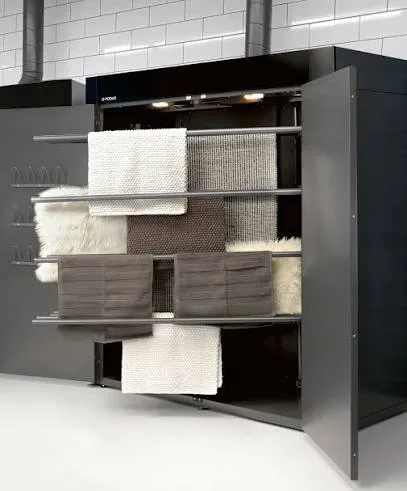 Drying cabinet with shelves and rails holding towels, knitwear and sheepskin