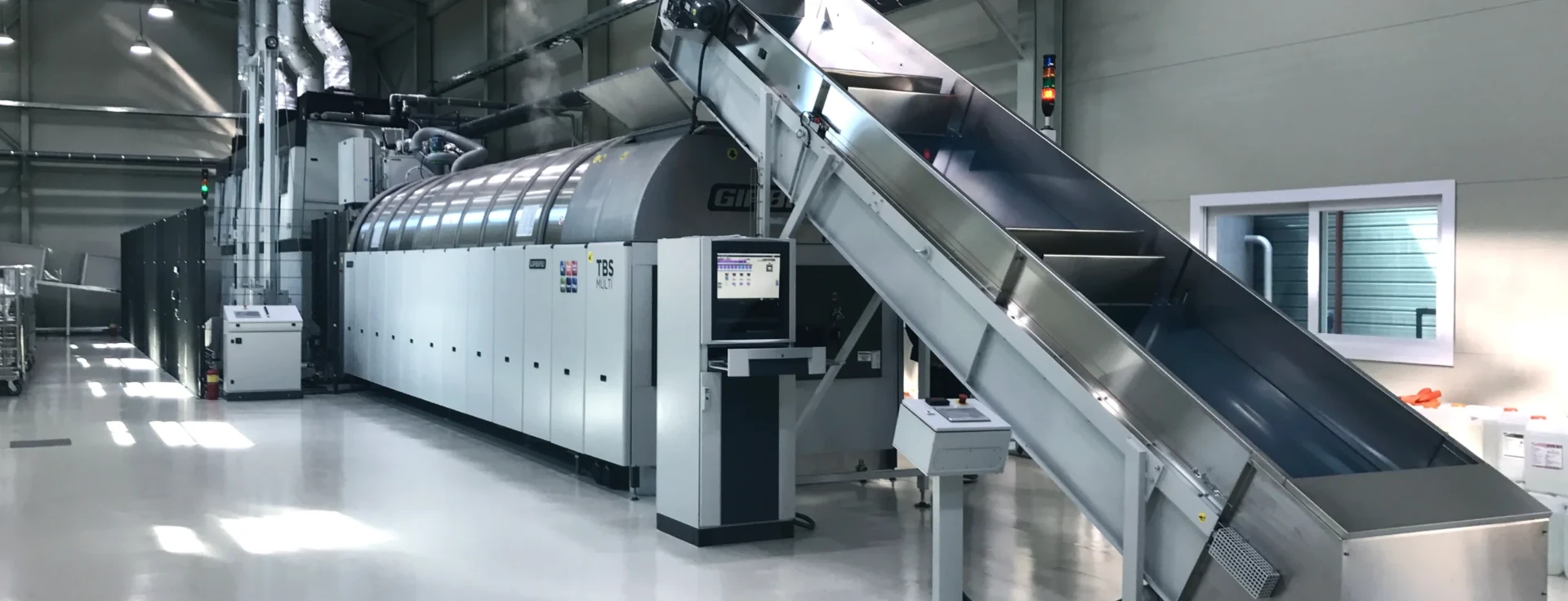 Girbau washer extractor, dryer and flatwork ironer running together on a central laundry floor