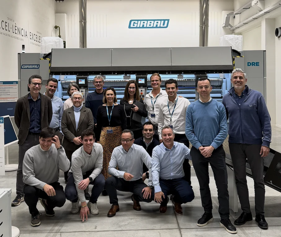 The Aqualogic team with the Girbau team in front of a Girbau industrial ironer