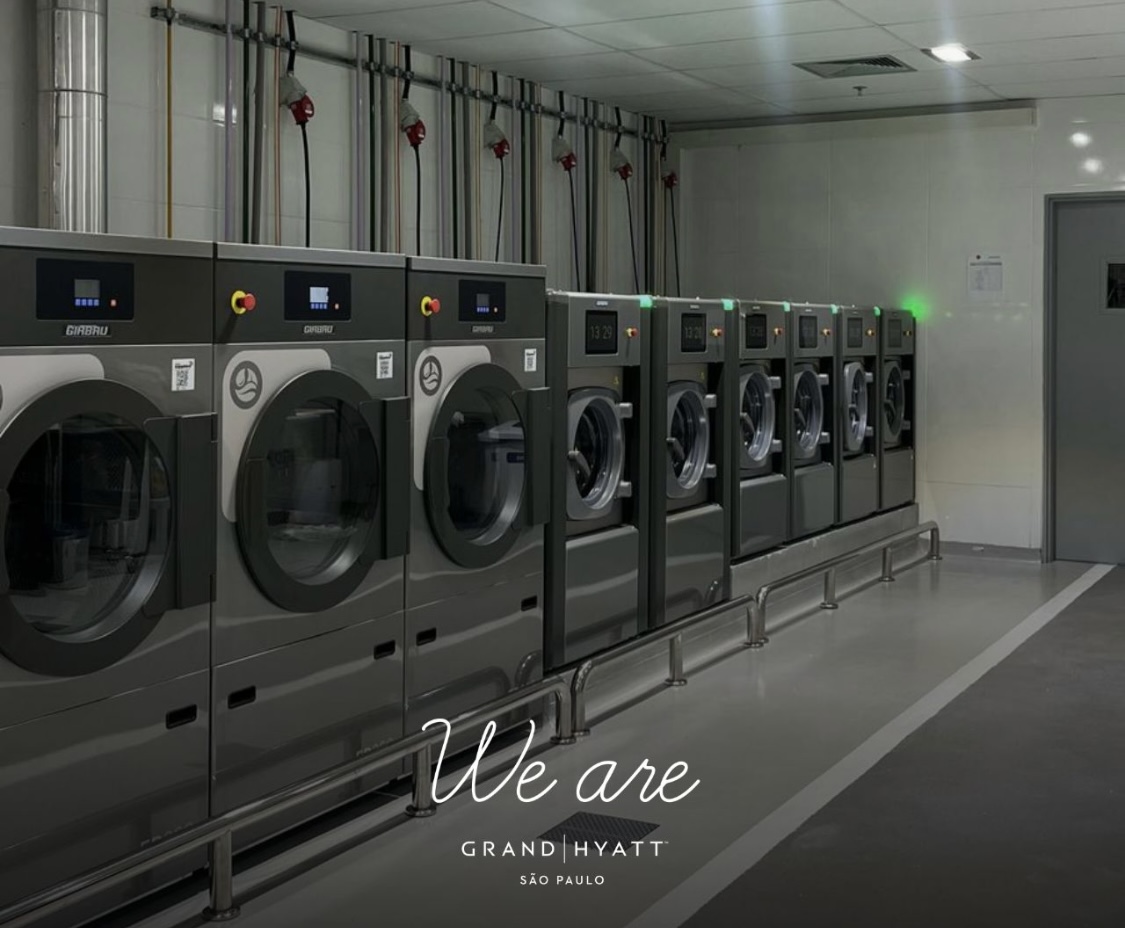 Row of three Girbau washer-extractors on floor plinths in an on-premise laundry